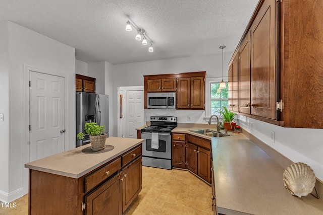 kitchen featuring stainless steel appliances, a sink, a center island, light countertops, and a textured ceiling