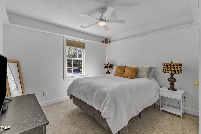 bedroom featuring a textured ceiling, baseboards, light colored carpet, and ceiling fan