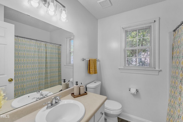 bathroom featuring toilet, vanity, a textured ceiling, and curtained shower