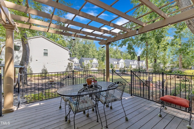 wooden deck with a residential view, a pergola, and outdoor dining space