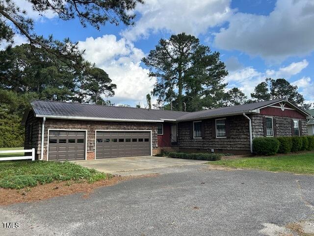 single story home featuring a garage and driveway