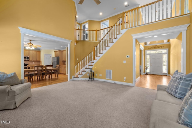 1420 Norwood Crest Ct, Raleigh, NC 27614 - living room with a ceiling fan, stairs, crown molding, a high ceiling, and baseboards