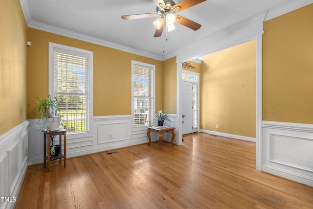1420 Norwood Crest Ct, Raleigh, NC 27614 - empty room with healthy amount of natural light, crown molding, a wainscoted wall, ceiling fan, and light wood-type flooring