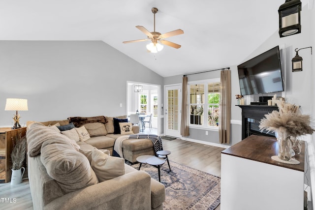 living room with a ceiling fan, high vaulted ceiling, wood finished floors, and a fireplace