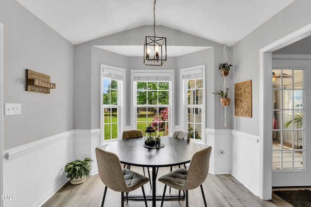 dining room with vaulted ceiling, a wealth of natural light, and light wood-style flooring