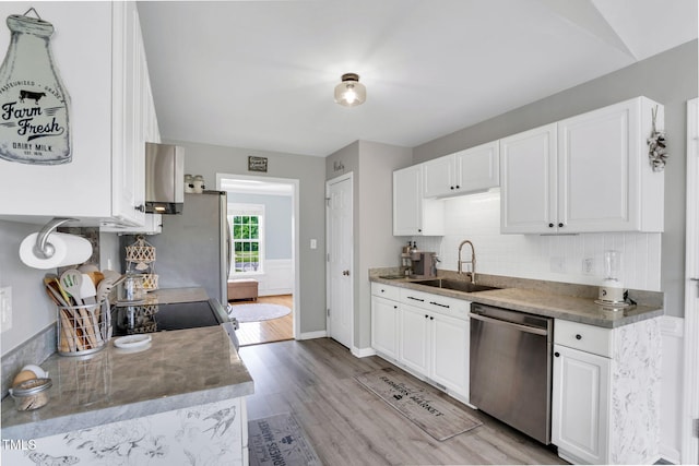 kitchen with backsplash, dishwasher, a sink, light wood-style floors, and white cabinetry