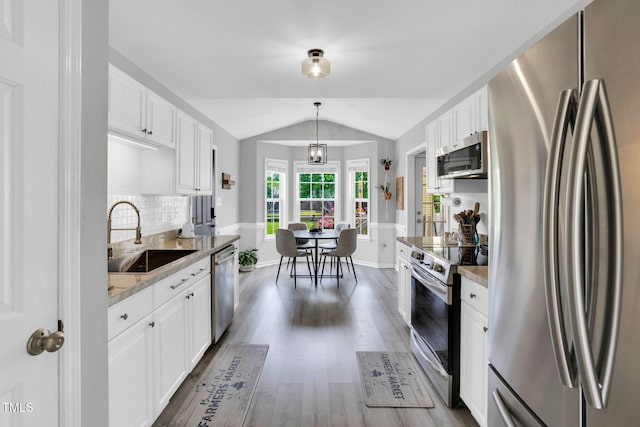kitchen with a sink, white cabinets, stainless steel appliances, and dark wood finished floors