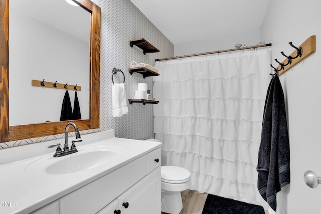 full bath featuring vanity, wood finished floors, toilet, wallpapered walls, and a shower with curtain