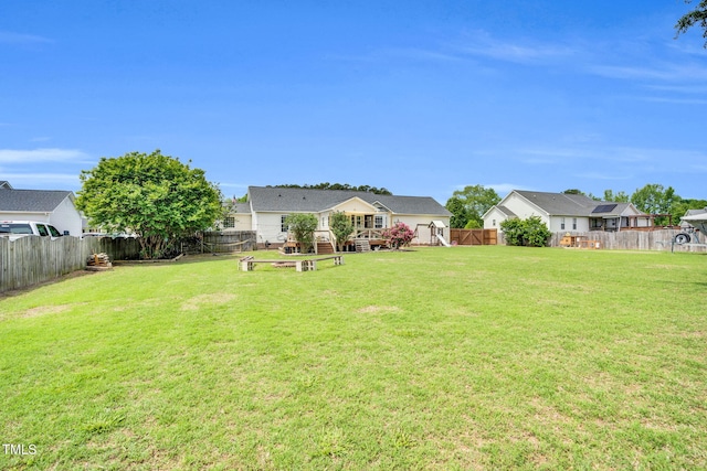 view of yard with a fenced backyard, a wooden deck, and an outdoor fire pit