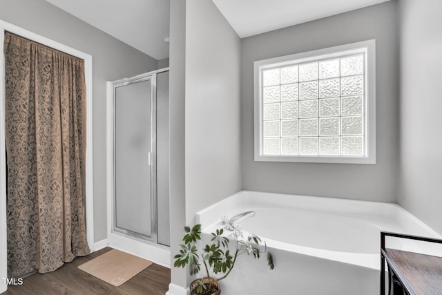 full bath featuring a garden tub, a stall shower, and wood finished floors