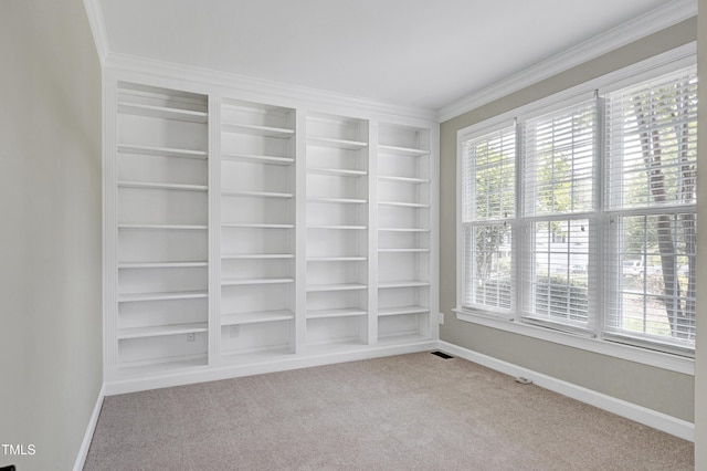 unfurnished room featuring crown molding, baseboards, and light carpet