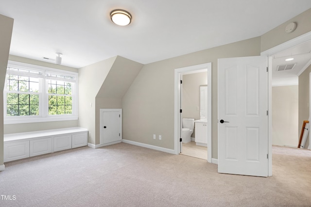 additional living space featuring baseboards, visible vents, and light carpet
