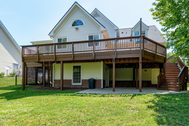 rear view of property with a wooden deck, a yard, and a patio area