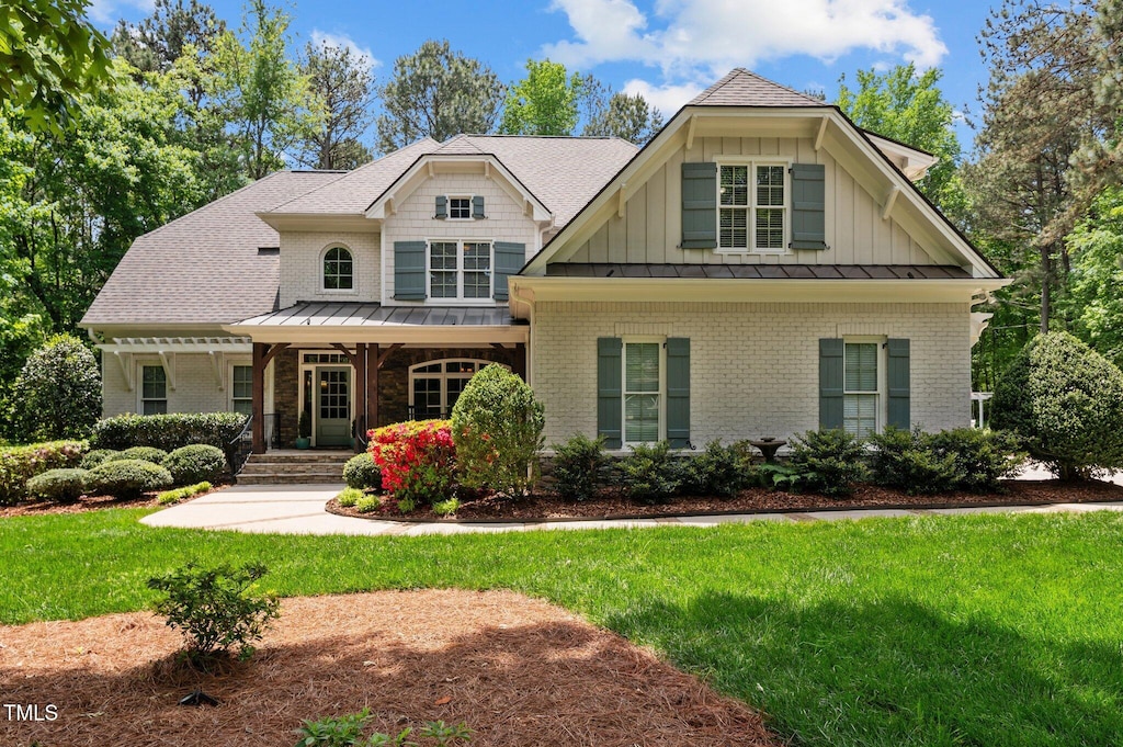 7400 Portpatrick Ct, Wake Forest, NC 27587 - craftsman inspired home featuring brick siding, a porch, a front yard, a standing seam roof, and metal roof