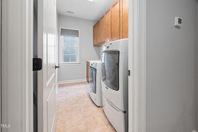 laundry room featuring cabinet space, baseboards, light tile patterned floors, visible vents, and washer and clothes dryer