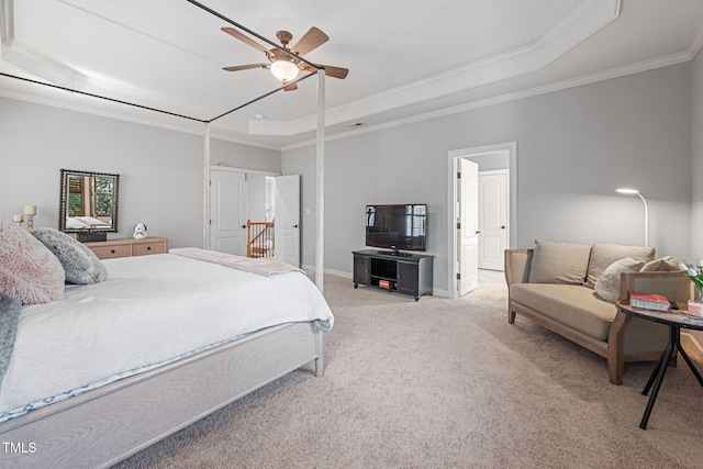 carpeted bedroom featuring crown molding, a raised ceiling, baseboards, and a ceiling fan