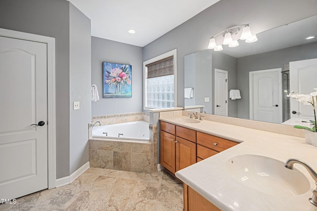 full bath with double vanity, baseboards, a sink, and a garden tub