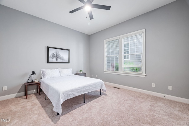 bedroom with baseboards, visible vents, light carpet, and ceiling fan