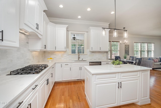 2728 Cameron Pond Dr, Cary, NC 27519 - kitchen with a sink, gas cooktop, a center island, ornamental molding, and white cabinets