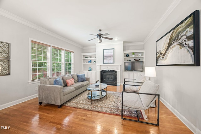 2728 Cameron Pond Dr, Cary, NC 27519 - living room with a ceiling fan, a glass covered fireplace, wood finished floors, crown molding, and baseboards