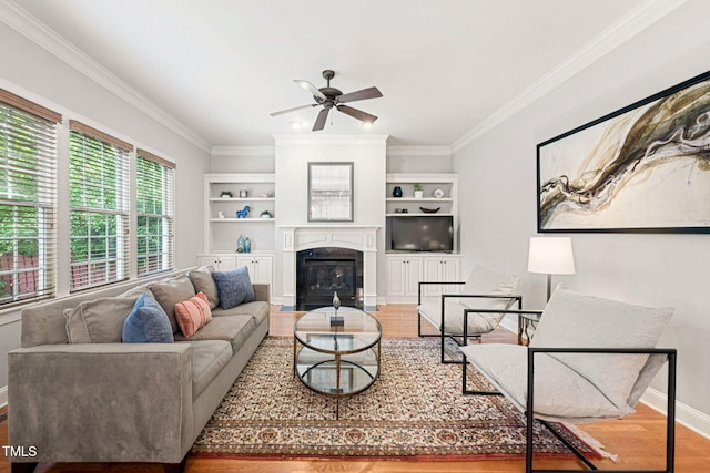 2728 Cameron Pond Dr, Cary, NC 27519 - living room featuring wood finished floors, ceiling fan, a glass covered fireplace, crown molding, and baseboards