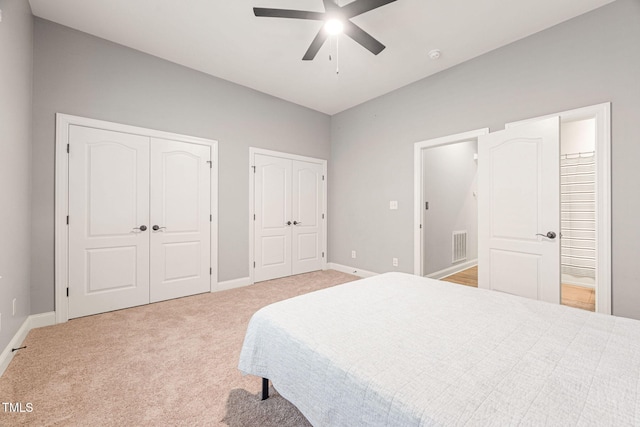 2728 Cameron Pond Dr, Cary, NC 27519 - bedroom with two closets, light colored carpet, ensuite bath, baseboards, and a ceiling fan