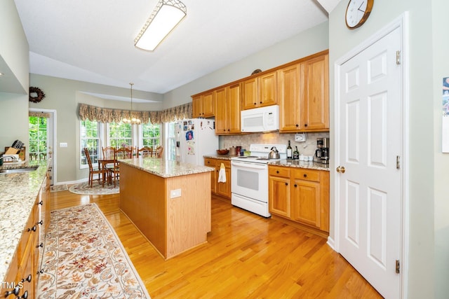 437 New Parkside Dr, Chapel Hill, NC 27516 - kitchen with a kitchen island, vaulted ceiling, a sink, light wood finished floors, and white appliances