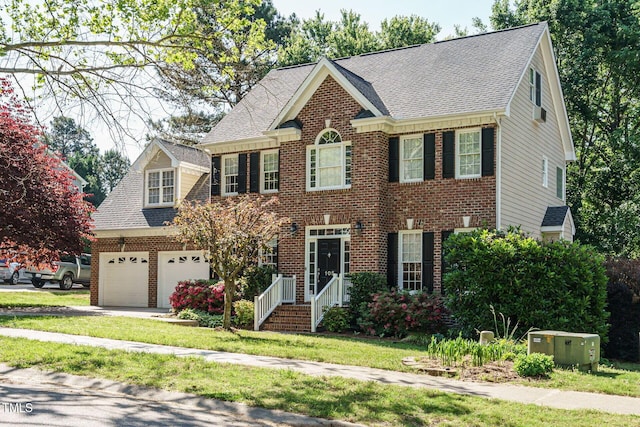 colonial home featuring concrete driveway, brick siding, an attached garage, and a shingled roof