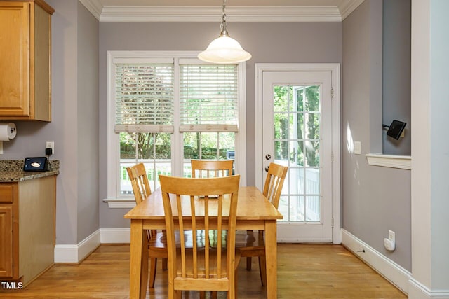 dining area with crown molding, light wood-style floors, and plenty of natural light