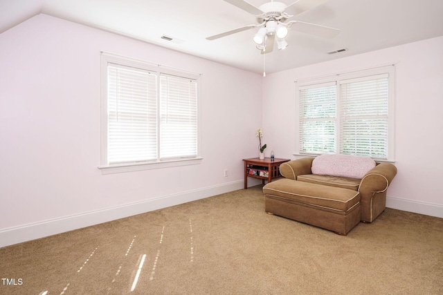 living area featuring carpet floors, baseboards, and a ceiling fan