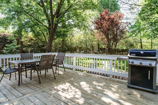 wooden terrace featuring outdoor dining area and grilling area