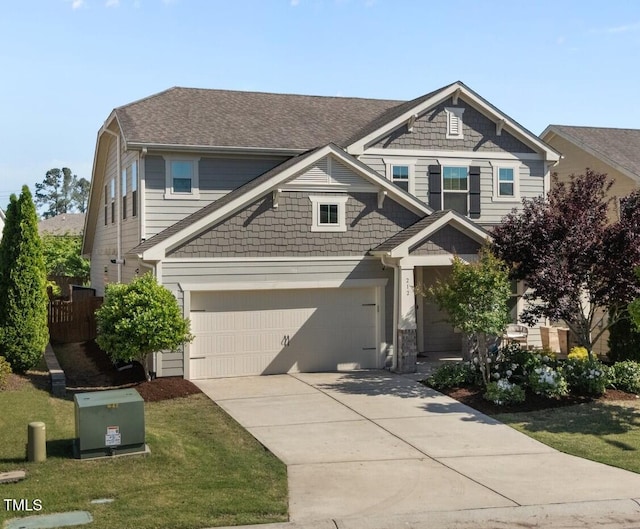 craftsman-style house with concrete driveway, a front lawn, roof with shingles, and a garage