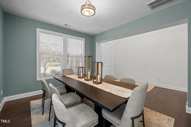 dining room with visible vents, baseboards, and dark wood-style flooring
