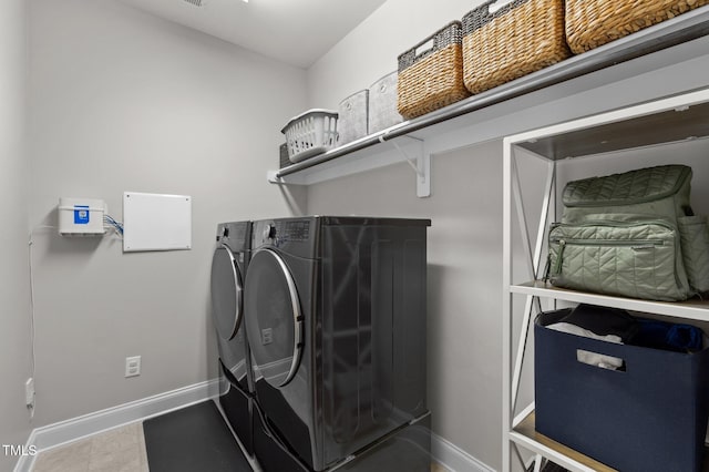 laundry area featuring baseboards, laundry area, and washer and clothes dryer