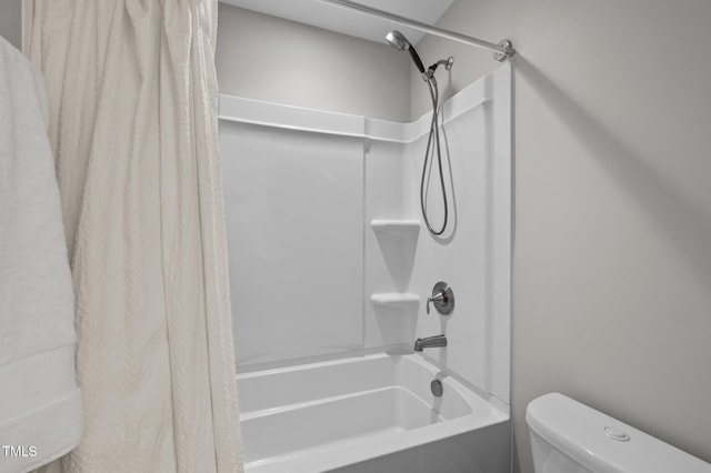 bathroom featuring shower / tub combo and toilet