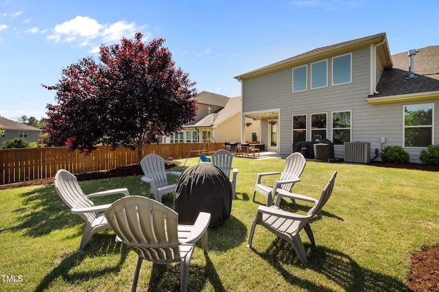 back of house featuring fence, roof with shingles, a patio area, central air condition unit, and a yard