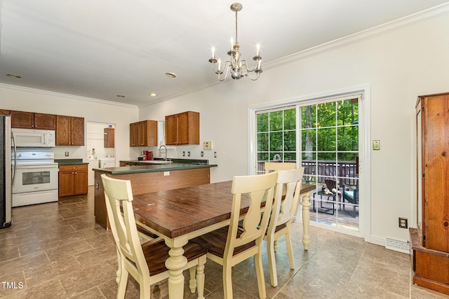 1176 Stoney Mountain Rd, Rougemont, NC 27572 - dining room with crown molding, a chandelier, dark stone finish flooring, and washing machine and clothes dryer