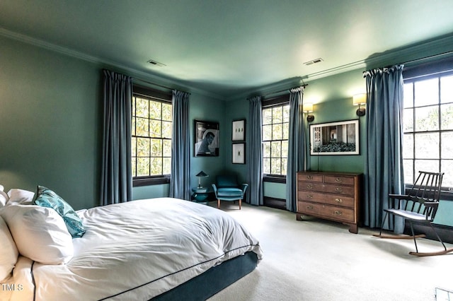 carpeted bedroom featuring ornamental molding, visible vents, and multiple windows