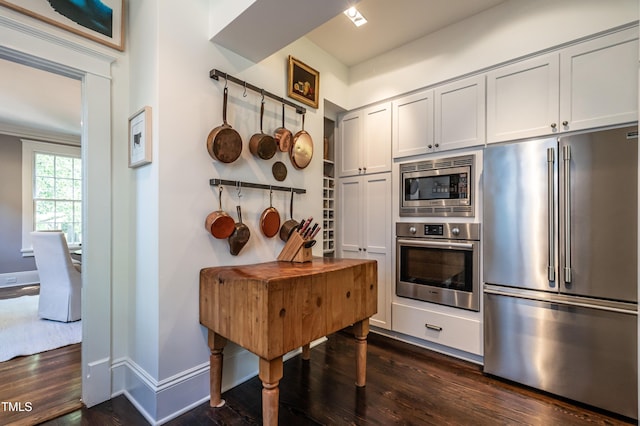 kitchen with dark wood-style flooring, baseboards, and appliances with stainless steel finishes