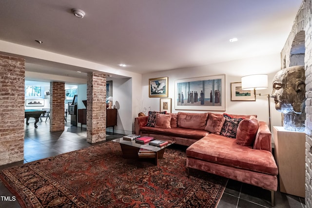 living area featuring tile patterned flooring and decorative columns