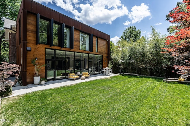 back of property featuring fence and a lawn