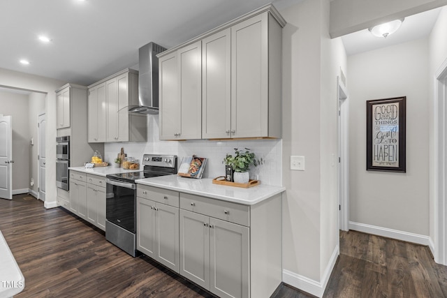 kitchen featuring appliances with stainless steel finishes, baseboards, recessed lighting, and wall chimney exhaust hood