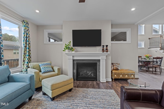 living area with a glass covered fireplace, plenty of natural light, recessed lighting, and wood finished floors