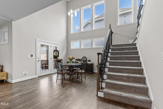 interior space featuring a healthy amount of sunlight, baseboards, stairs, and wood finished floors