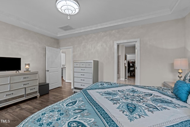 bedroom with visible vents, ornamental molding, a tray ceiling, and dark wood-type flooring