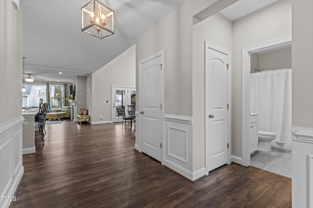 entrance foyer with dark wood finished floors, ceiling fan with notable chandelier, and lofted ceiling