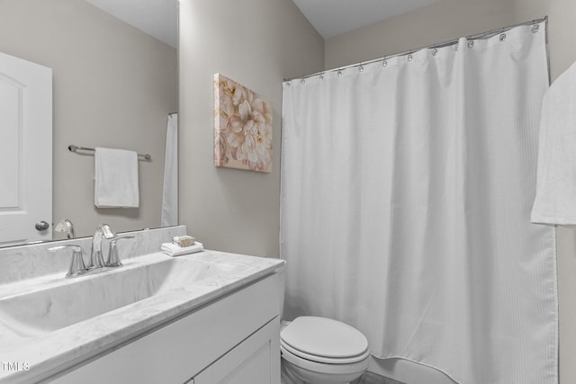 bathroom featuring toilet, a shower with shower curtain, and vanity