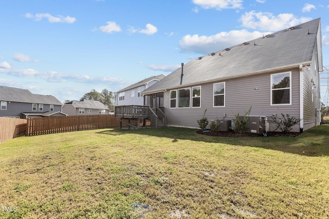 rear view of property with a fenced backyard, a lawn, a sunroom, and stairway