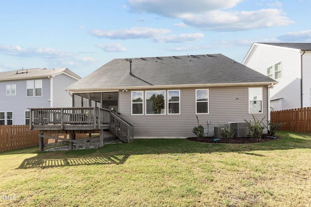 rear view of property featuring a lawn, a sunroom, cooling unit, a fenced backyard, and a shingled roof