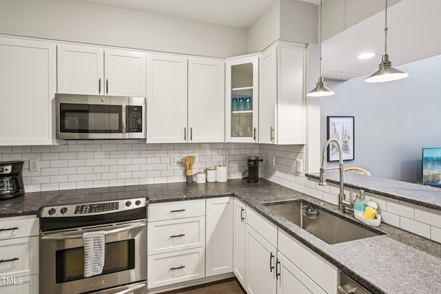 200 S Dawson St Unit 114, Raleigh, NC 27601 - kitchen featuring stainless steel appliances, white cabinetry, backsplash, glass insert cabinets, and hanging light fixtures